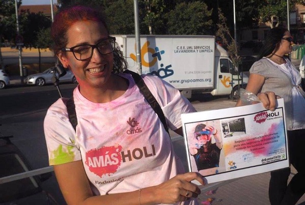 Una de las participantes en AMÁS Holi recoge uno de los premios aportados por las empresas solidarias de Fuenlabrada.