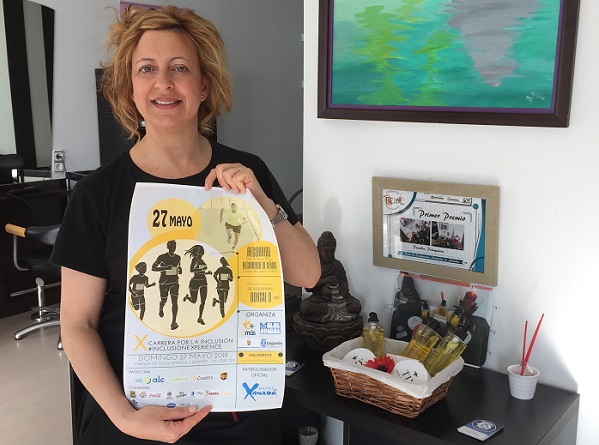 Celia de la Cruz, propietaria de "Duendes Peluqueros" muestra el cartel de la X Carrera por la Inclusión. Foto: Fundación AMÁS